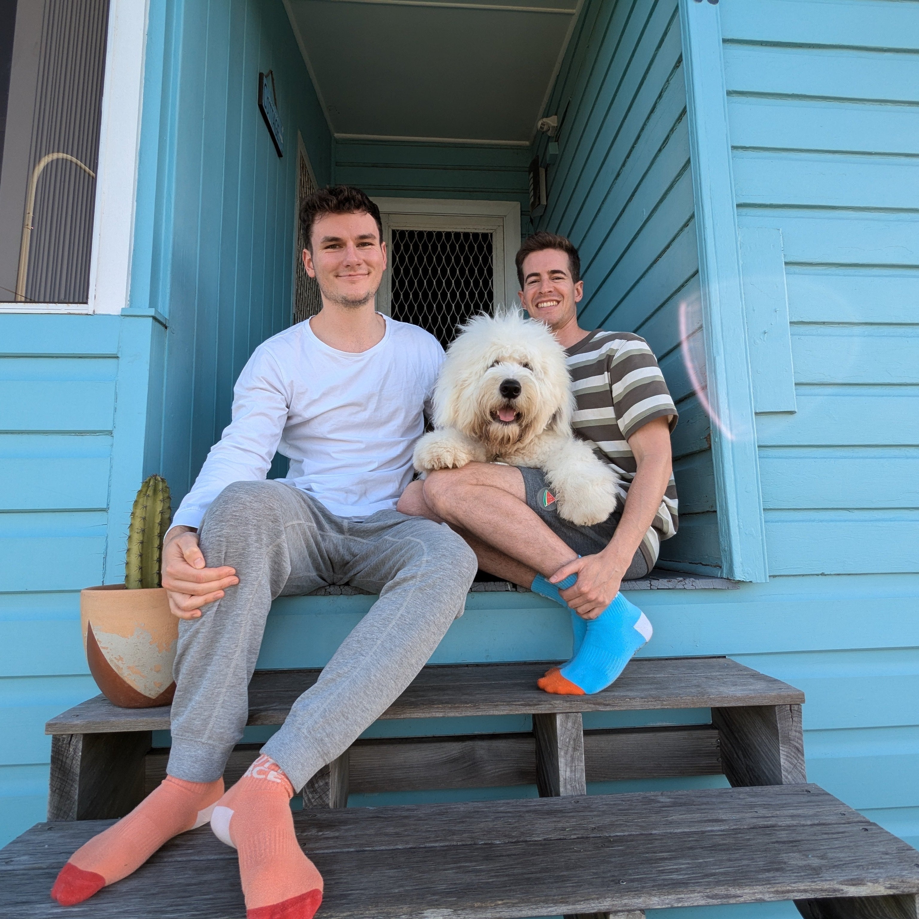 Two guys and their Old english sheepdog sitting on their front step in sunny Kiama